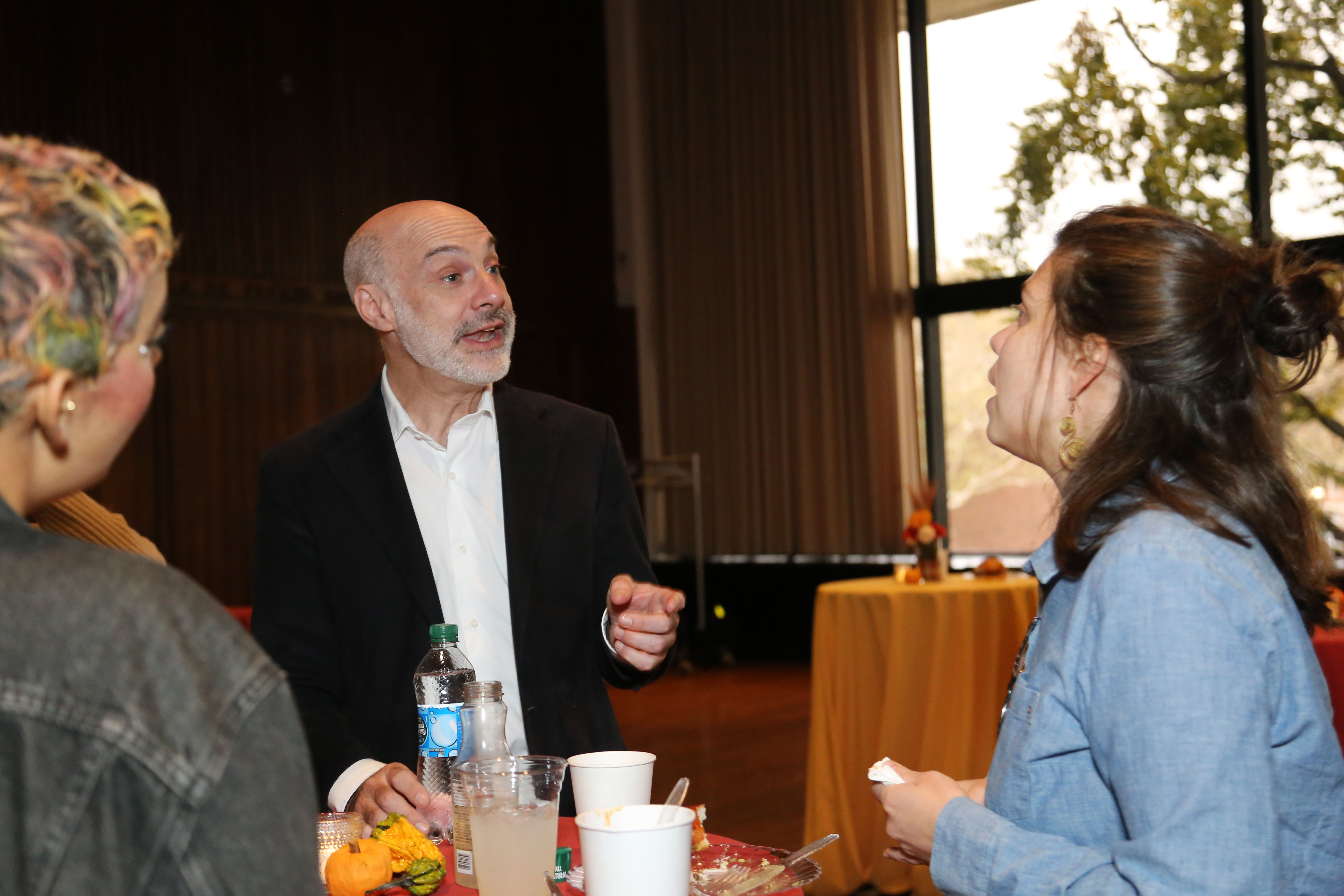 Dean Agustin Rayo and two Fall Fair attendees talk at a table