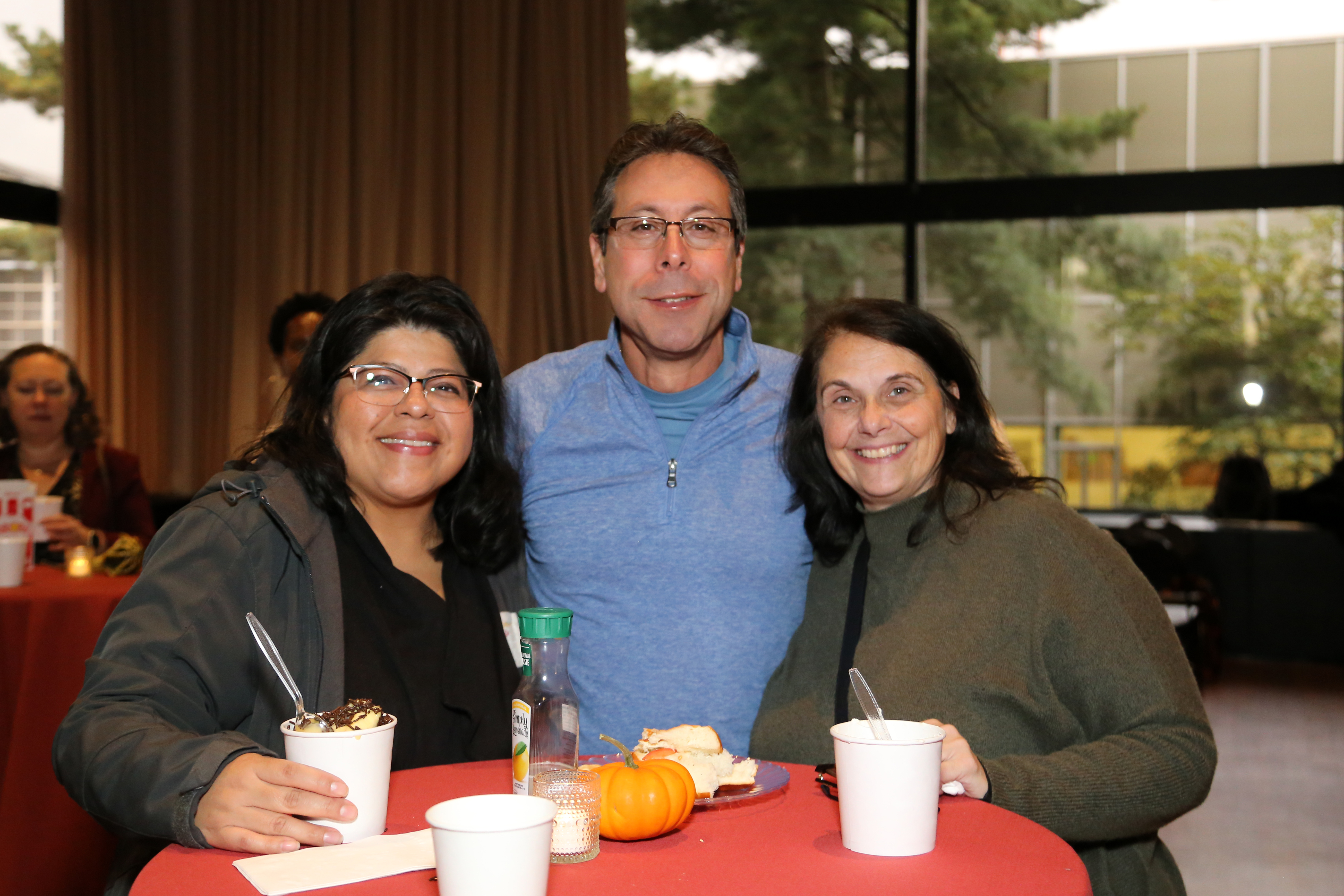 Ana Ludwig, Erminia Piccinonno, and a Fall Fair attendee in a blue Oxford shirt and glasses at a table