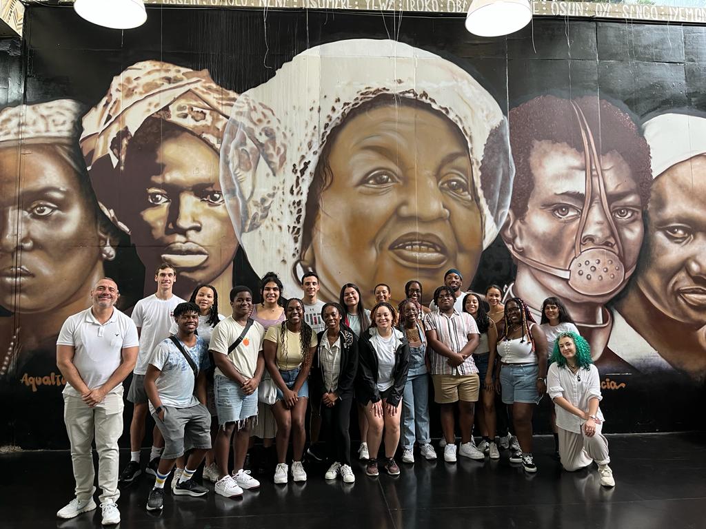 MIT SHASS students and staff in front of a mural during an IAP trip to Brazil