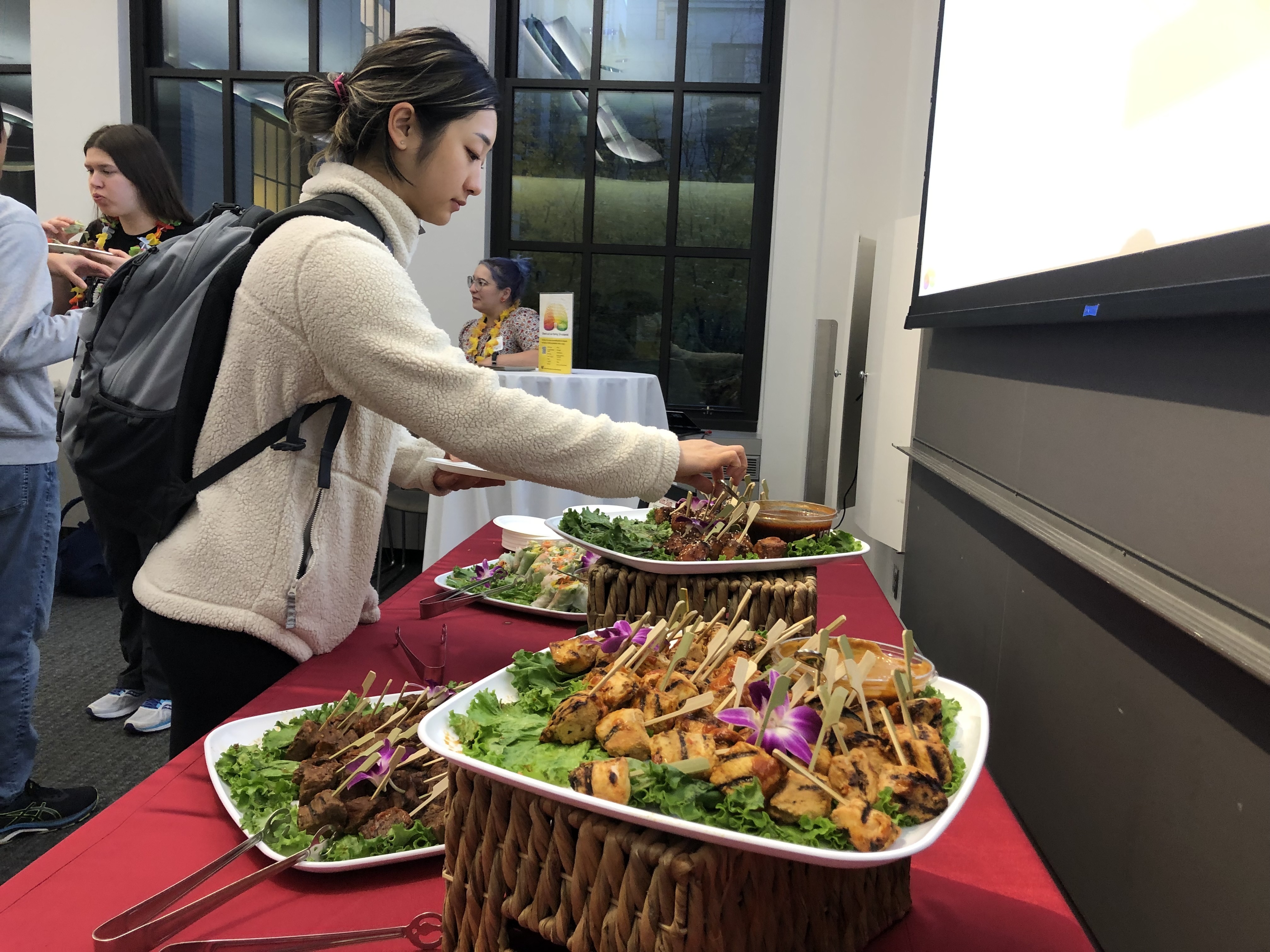 A student samples some of the food available at the Spring Ahead with SHASS event