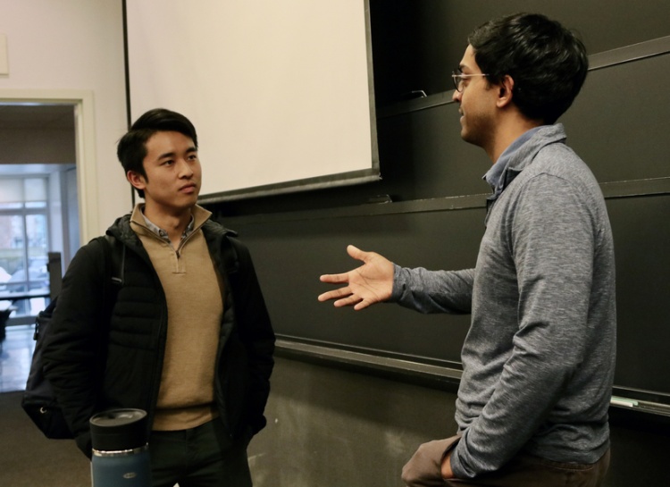 Professor Ashesh Rambachan (right) confers with a student following an Algorithms and Behavioral Science class.