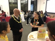 MIT School of Humanities, Arts, and Social Sciences Dean Agustin Rayo, wearing a lei, speaks with a student during the Spring Ahead With SHASS event