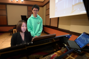 Mi-Eun Kim (seated), pianist and lecturer at MIT Music and Theater Arts, and student Holden Mui interact with the Steinway Spirio.