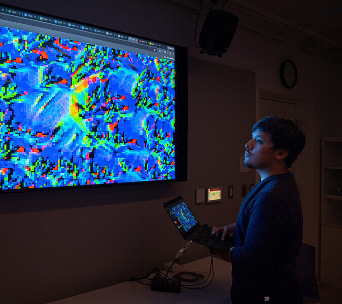 An image of MIT student Mariano Salcedo working with neurocellular automata on a computer