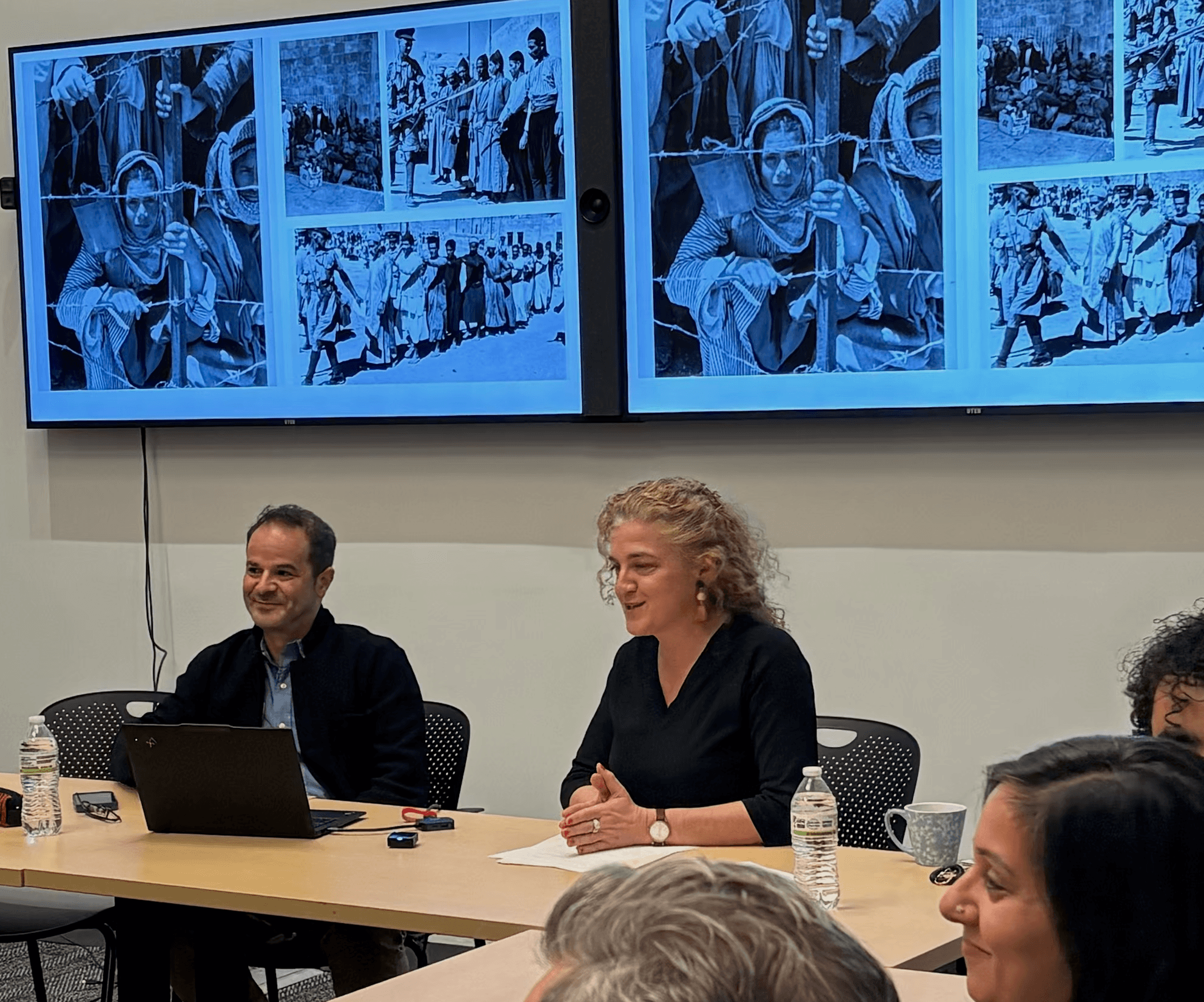 Fadi Asla (left) and Lerna Ekmekcioglu at the opening of the lecture, with Mandate-era photographs of Palestinian detainees on the screens behind them